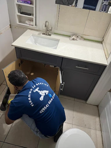 Plumbing 24 Service plumber repairing under-cabinet plumbing in Tamarac FL