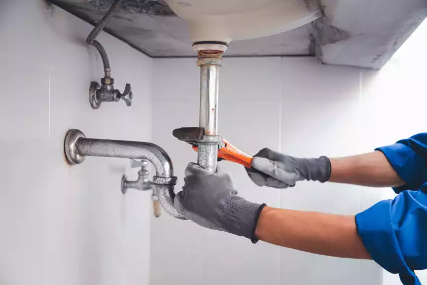 Professional plumber repairing pipes in Broward County home